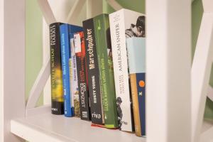 a row of books sitting on a shelf at GREENs - ruhige schöne 1RWhg gut gelegen mit Balkon in Dresden