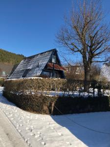 Gossersweiler-SteinにあるFerienhaus-Rosensteig-128-im-Feriendorf-Eichwaldの雪屋根の家