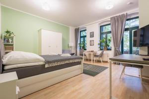 een slaapkamer met een bed, een bureau en een tafel bij GREENs - ruhige schöne 1RWhg gut gelegen mit Balkon in Dresden