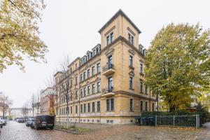 ein großes Backsteingebäude an einer Stadtstraße in der Unterkunft GREENs - ruhige schöne 1RWhg gut gelegen mit Balkon in Dresden