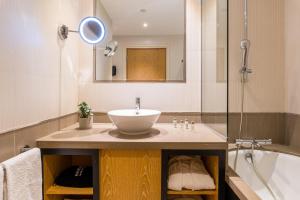 a bathroom with a sink and a bath tub at Golden Tulip Villa Massalia in Marseille