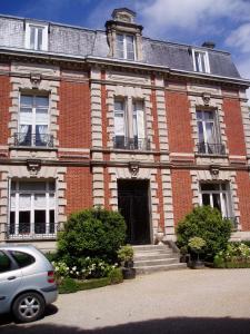 a car parked in front of a brick building at Hotel Le Clos Raymi in Épernay