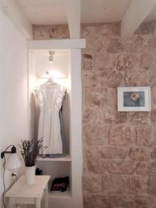 um vestido pendurado num quarto com uma parede de tijolos em Casa Ruben, private stone house em Vis