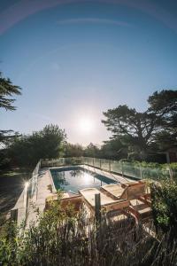 a swimming pool with chairs and the sun in the sky at Cabañas del Golf in Sierra de la Ventana +27 photos