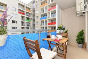Apartamento con piscina y balcón con mesa y sillas. en Laurel Bay Apartment, en Budapest