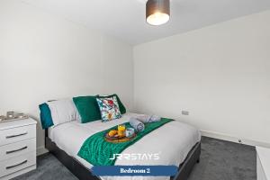 a bedroom with a bed with a tray of fruit on it at Tipton 3 Bedroom House Garden Sleeps 7 - JRR Stays in Coseley