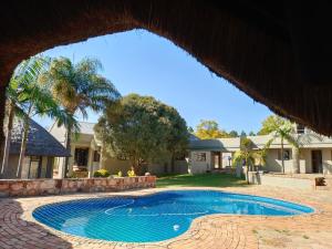 a swimming pool in front of a house at Beynespoort Farm in Cullinan