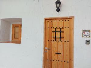 una puerta de madera en una pared blanca con un espejo en Apartamento Bulería, en Jerez de la Frontera