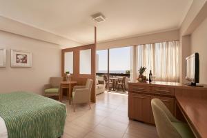 a hotel room with a bed and a living room at Atlantica Oasis Hotel in Limassol