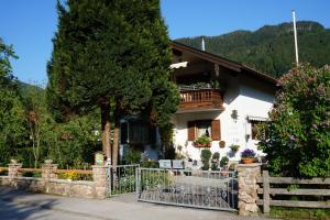 a house with a fence in front of it at Ferienwohnung Haus Jennerwein in Sachrang