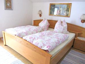 Schlafzimmer mit einem Bett mit rosa Bettwäsche und Kissen in der Unterkunft Ferienwohnung Haus Jennerwein in Sachrang