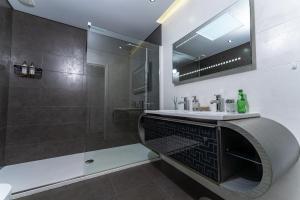 a bathroom with a sink and a shower at Golf Course - Luxurious Flat T3 - Ponte de Lima in Ponte de Lima