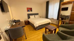 um quarto de hotel com uma cama, uma mesa e cadeiras em Akomo Bern em Berna