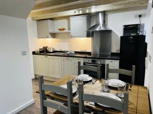 a kitchen with a table with chairs and a stove at Barn Cottage in Frome