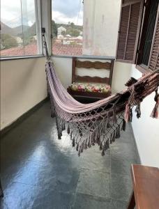 uma rede de descanso num quarto com uma janela em Imperdível - Casa aconchegante com varanda em Ouro Preto