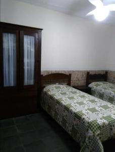 Imperdível - Casa aconchegante com varanda في أورو بريتو: غرفه فندقيه سريرين وسقف