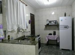 a kitchen with a white refrigerator and a sink at Imperdível - Casa aconchegante com varanda in Ouro Preto