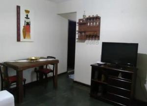 uma sala de estar com uma mesa e uma televisão em Imperdível - Casa aconchegante com varanda em Ouro Preto