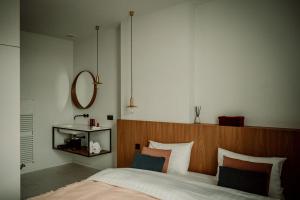 - une chambre avec un grand lit et une tête de lit en bois dans l'établissement Relais M B&B, à Frasnes-lez-Anvaing