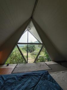 Zimmer mit einem großen Fenster in einem Zelt in der Unterkunft Royal mountain view Ratchaburi in Ratchaburi