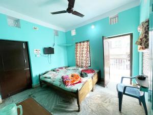 a bedroom with a bed in a room with blue walls at Radha Krishna Holiday Home in Puri