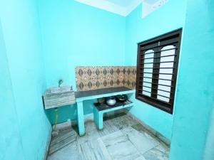 a blue room with a sink and a window at Radha Krishna Holiday Home in Puri