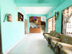 a living room with blue walls and a couch at Radha Krishna Holiday Home in Puri