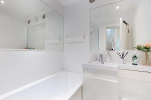 a white bathroom with two sinks and a mirror at Stunning 3 Bed London Townhouse in London