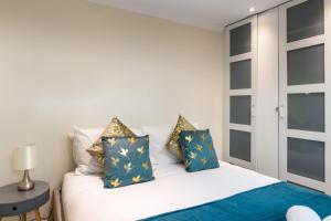 a bedroom with a bed with blue and gold pillows at Stunning 3 Bed London Townhouse in London