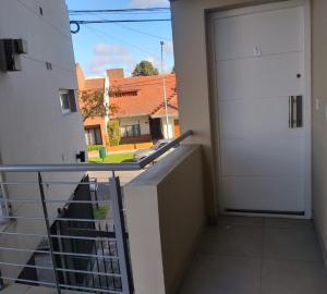 a door to a balcony with a view of a house at Wenuray MdQ in Mar del Plata