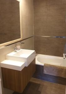 a bathroom with a white sink and a bath tub at Wenuray MdQ in Mar del Plata