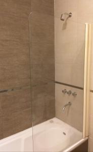 馬德普拉塔的住宿－Wenuray MdQ，带淋浴的浴室和玻璃门