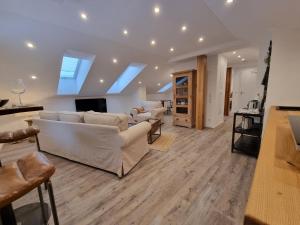 een woonkamer met witte banken en een tv bij Zollhaus 65 in Reit im Winkl