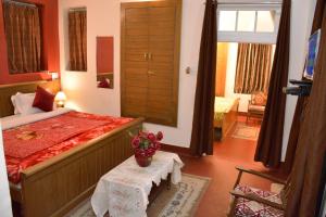 een slaapkamer met een bed en een tafel met bloemen erop bij Solan Retreat in Solan