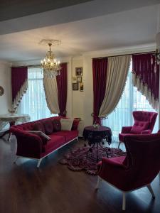 uma sala de estar com um sofá vermelho e janelas em Old Tbilisi Apartment em Tbilisi