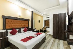 a bedroom with a large bed with red pillows at Hotel Kochi Crown in Cochin