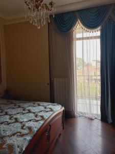 um quarto com uma cama e uma grande janela em Old Tbilisi Apartment em Tbilisi
