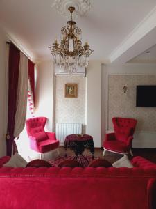 uma sala de estar com um sofá vermelho e duas cadeiras em Old Tbilisi Apartment em Tbilisi