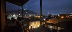 uma vista de uma cidade à noite a partir de um edifício em Old Tbilisi Apartment em Tbilisi