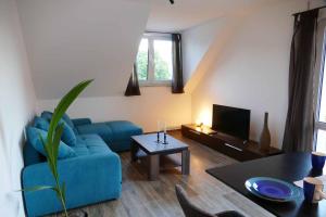 a living room with a blue couch and a tv at Ferienwohnungen Brombachsee in Pleinfeld