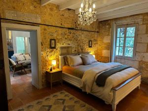 a bedroom with a bed and a chandelier at the Snug House in Maurens