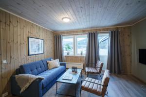 een woonkamer met een blauwe bank en een tafel bij Bjorli Fjellstuer - by Classic Norway Hotels in Bjorli