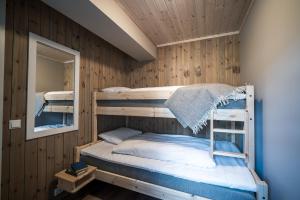 a bedroom with two bunk beds and a mirror at Bjorli Fjellstuer - by Classic Norway Hotels in Bjorli