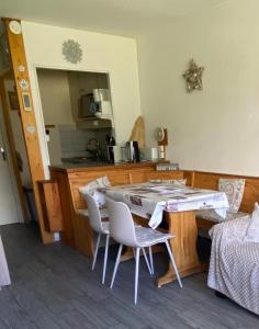 - une cuisine avec une table et des chaises dans la chambre dans l'établissement Le Cocon Eris, à La Mongie