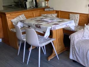 - une table et des chaises dans une chambre avec un lit dans l'établissement Le Cocon Eris, à La Mongie