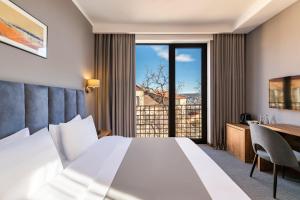 A bed or beds in a room at Barnovi Boutique Hotel