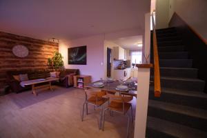 een woonkamer met een tafel en stoelen en een trap bij Snæfellsjökull Apartments in Snæfellsbær