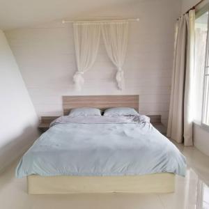 a bedroom with a large bed with white walls at 153 Mountain View in Ban Huai Phai