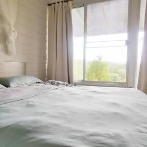 a bed in a room with a large window at 153 Mountain View in Ban Huai Phai