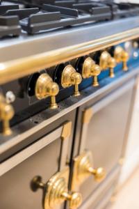 un primer plano de una estufa con perillas de oro en Luxury 3 bedrooms townhouse in perfect location, en Bruselas